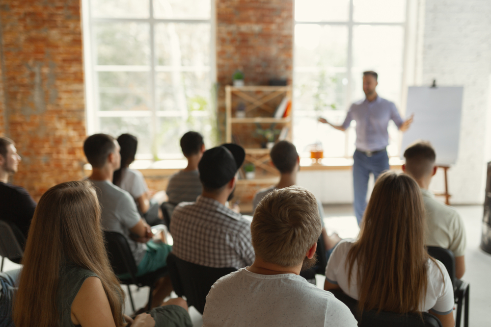 Male Speaker Giving a Presentation, in a Hall to a University Workshop Audience