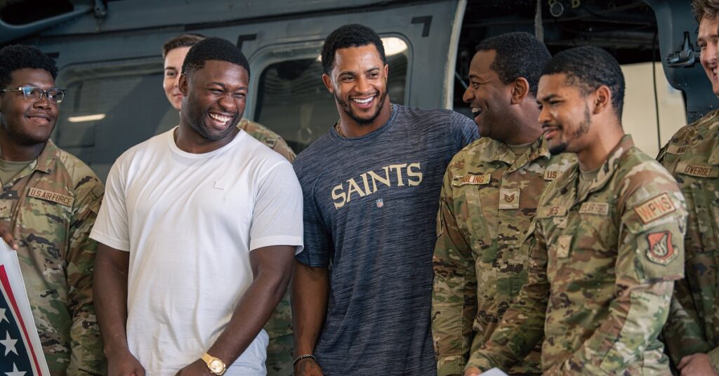 Airmen from the 33rd Helicopter Maintenance Unit laugh with Roquan Smith, left, and Jonathan Abram, right, during their visit to Kadena Air Base.