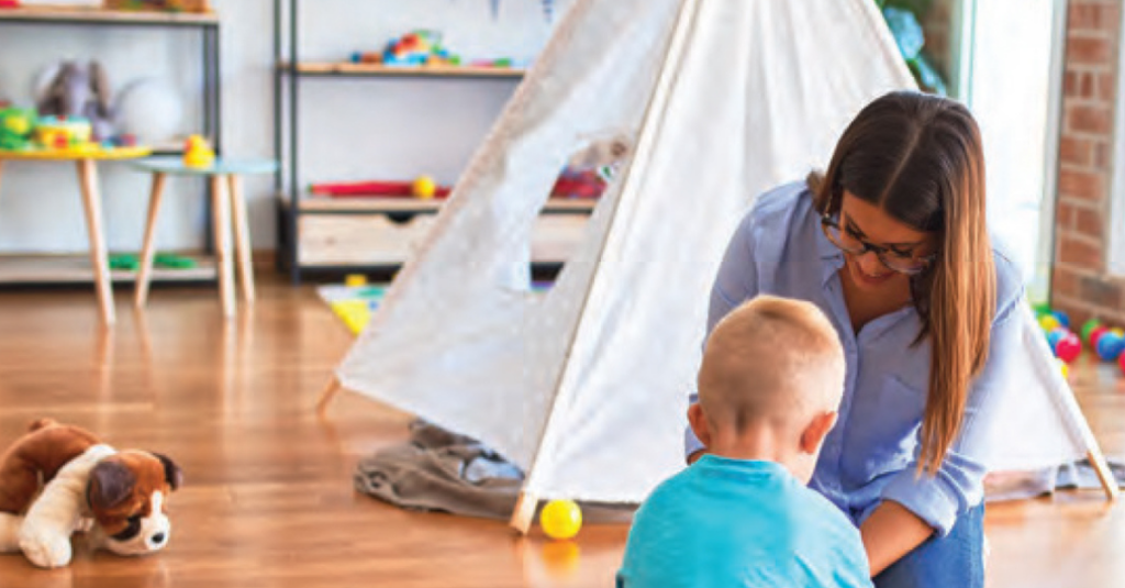 military spouse playing with child in livingroom with tent and toys in background