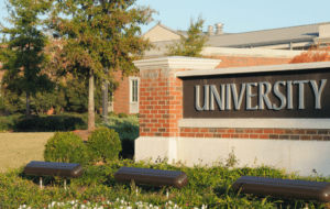 university building and sign set in greenery backdrop