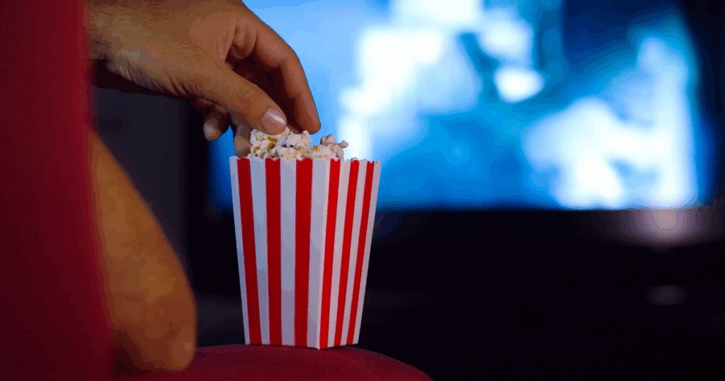 man with popcorn watching movie