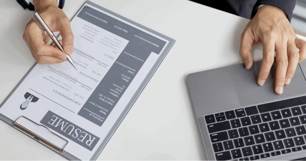 recruiter strategizing at desk with calculator an resume