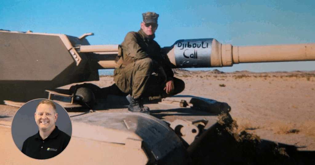 David Raymond sitting near Army tank