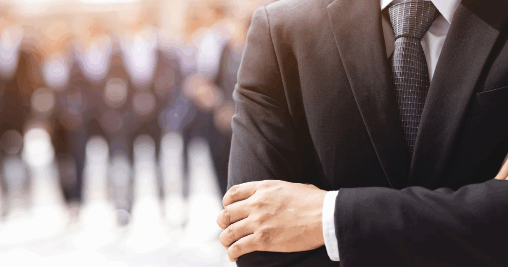 Man in business suit with arms folded looking confident