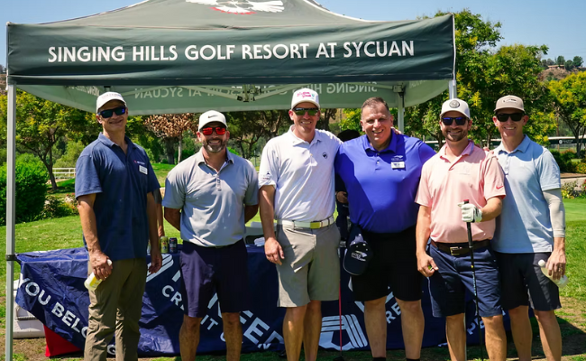 STEP Golf Event attendees in a row in front of the tent