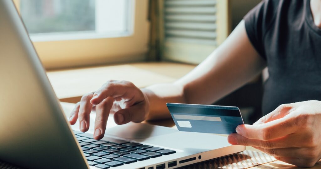 girl makes a purchase on the Internet on the computer with credit card