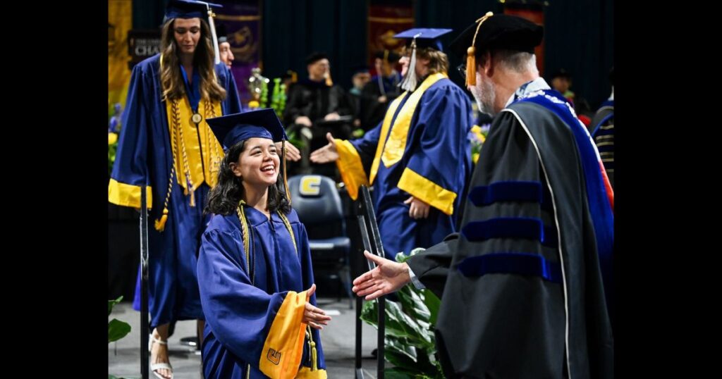 graduates shaking hands with other graduates