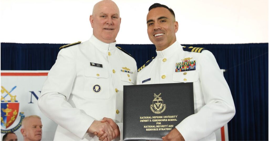 two marines in full dress holding plaque and shaking hands
