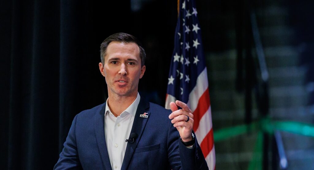 Sports & Fitness Industry Association’s VetsEXCEL Program SFIA's Todd Smith giving speech with US flag in background