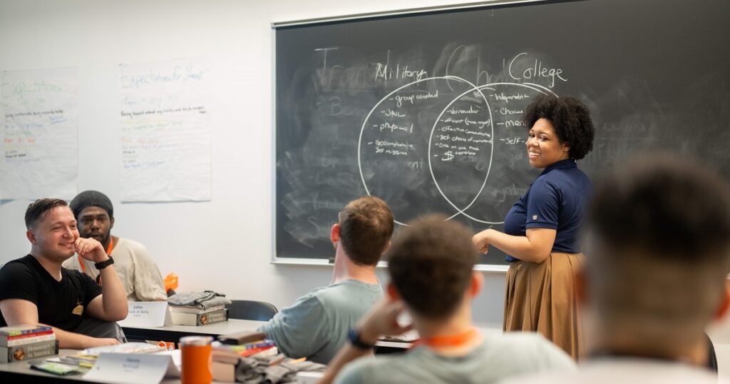 teacher explaining details on the chalkboard to college students