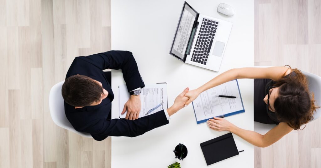Portrait Of Two Happy Businesswoman Having Handshake In Office